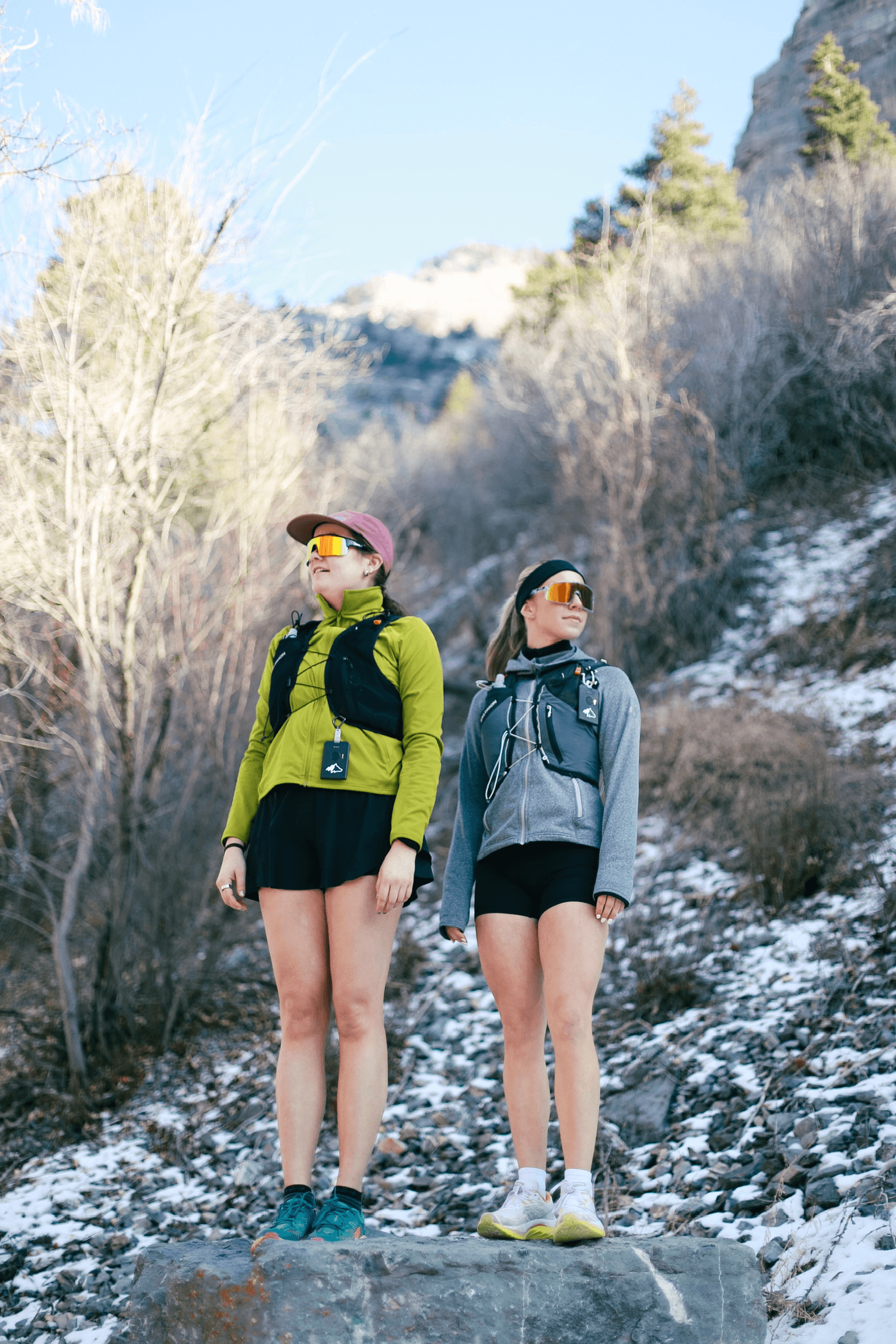 Two trail runners on snowy mountain path