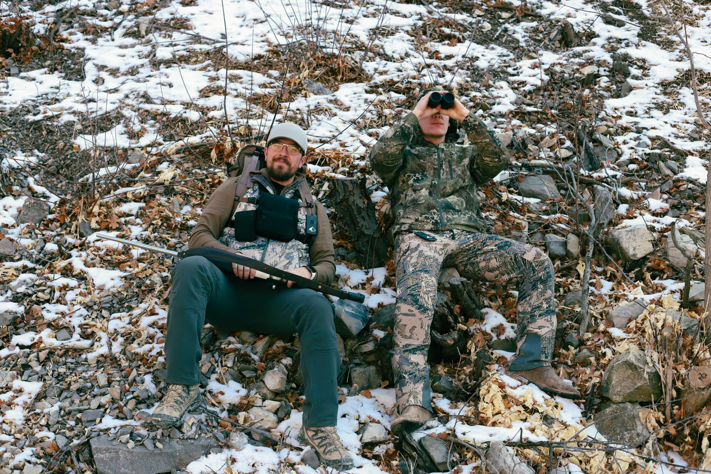 Two hunters glassing on snowy hillside