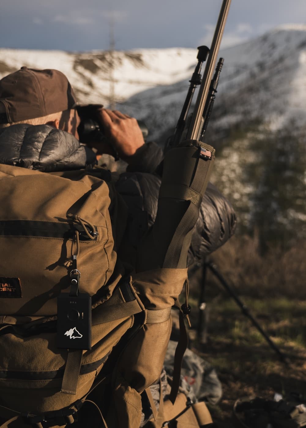 Hunter glassing a ridge with a Kiba radio on his pack