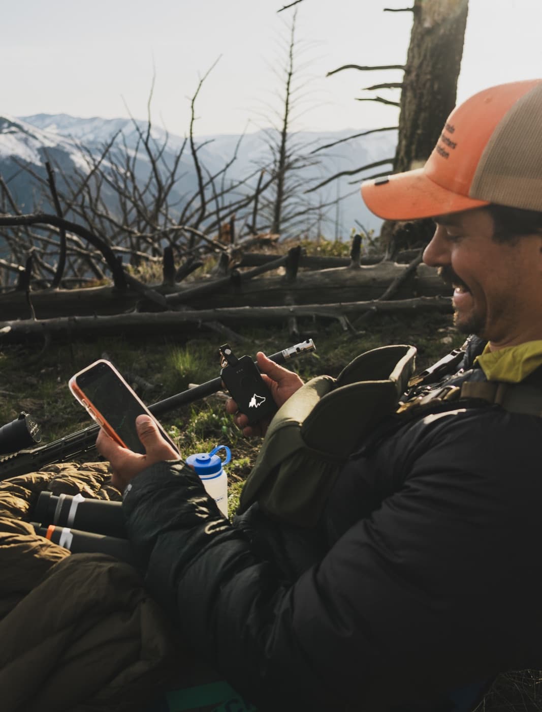 Hunter texting on his phone with a Kiba Scout in hand